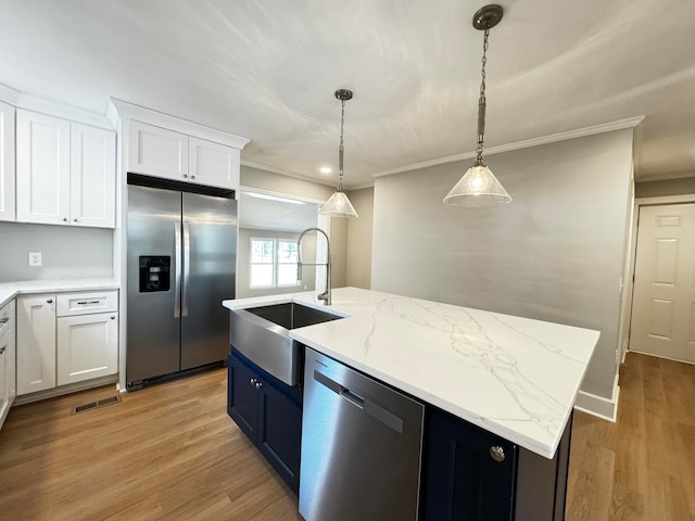 kitchen featuring light hardwood / wood-style flooring, hanging light fixtures, stainless steel appliances, and white cabinets