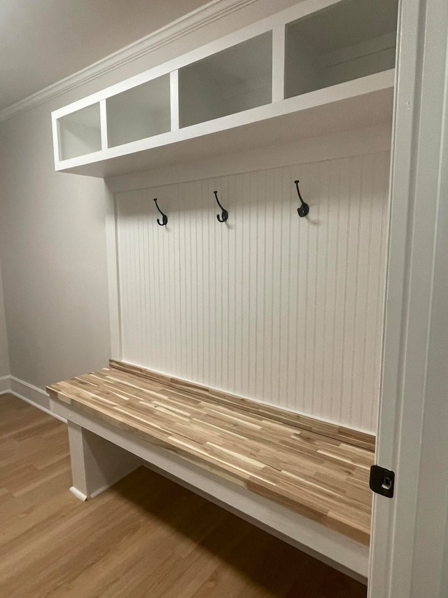 mudroom with crown molding and wood-type flooring