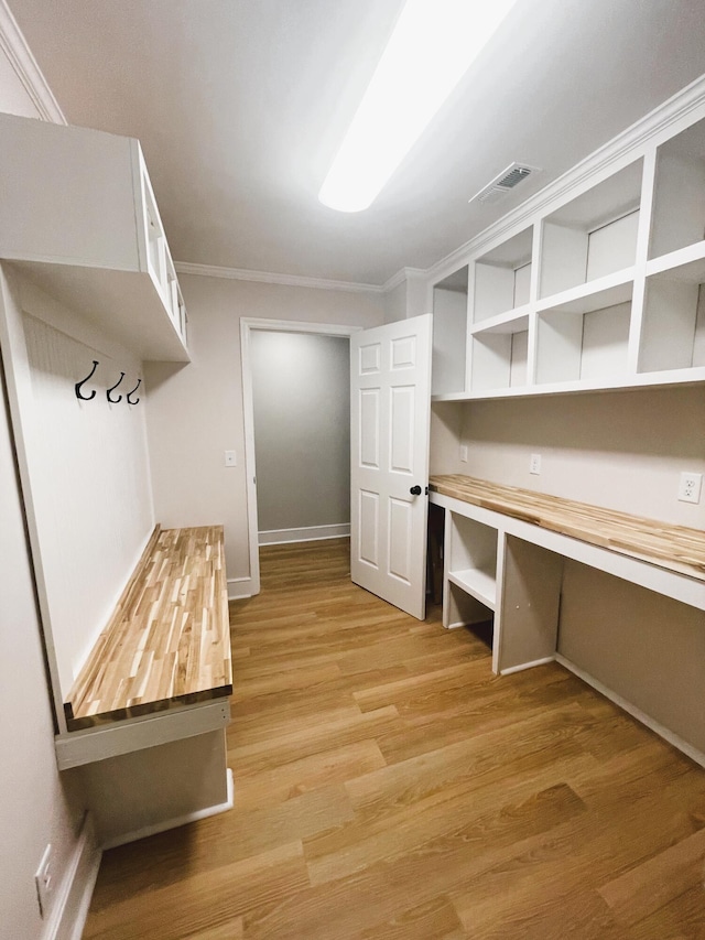 walk in closet with light hardwood / wood-style floors