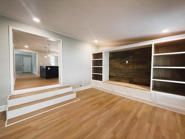 spare room with crown molding and light hardwood / wood-style flooring