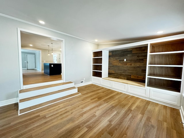 unfurnished living room featuring ornamental molding and light hardwood / wood-style floors