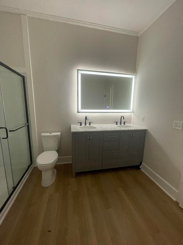 bathroom with walk in shower, hardwood / wood-style floors, toilet, double sink vanity, and ornamental molding