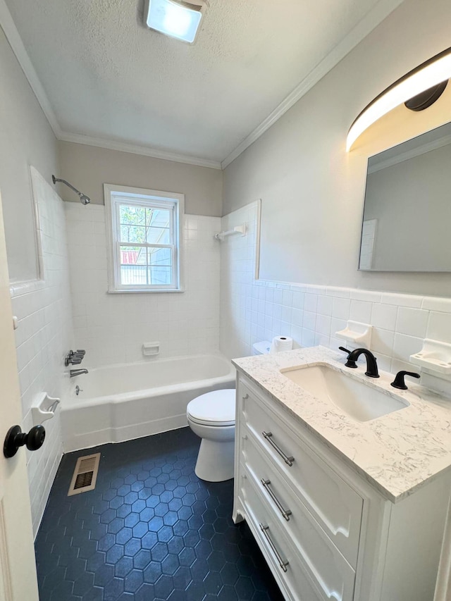 full bathroom with tile floors, a textured ceiling, toilet, vanity, and tiled shower / bath