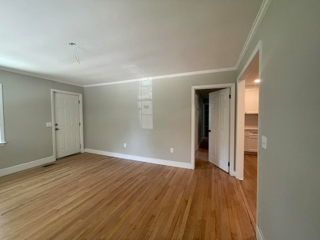 unfurnished room featuring ornamental molding and light hardwood / wood-style floors