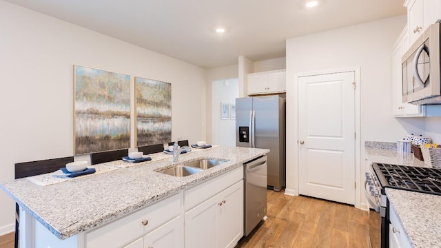 326 Watersglen Dr, Summerville, SC 29486 - kitchen with a sink, stainless steel appliances, light wood-style floors, white cabinetry, and recessed lighting