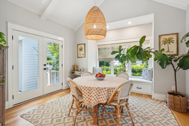 dining area featuring french doors, lofted ceiling with beams, and light wood-type flooring