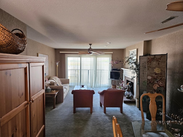 living room with a textured ceiling, dark carpet, and ceiling fan