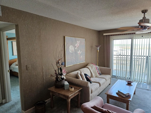 living room featuring carpet flooring, ceiling fan, and a textured ceiling