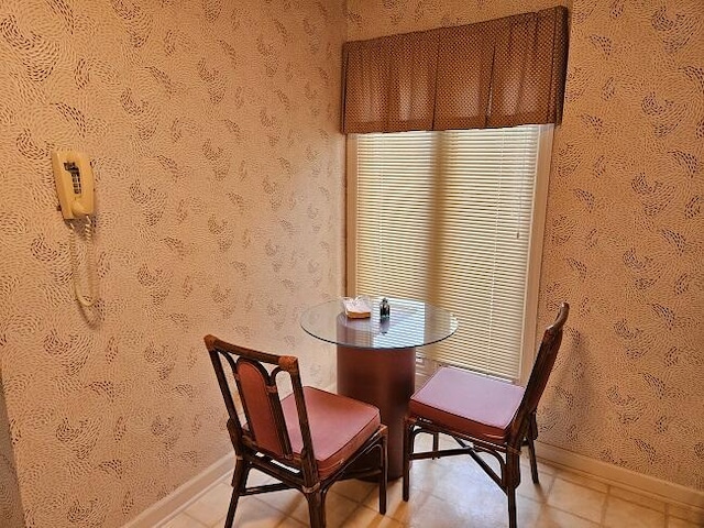 dining area with baseboards and wallpapered walls