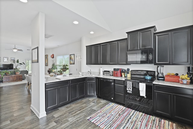192 Buchanan Cir, Goose Creek, SC 29445 - kitchen with black appliances, dark cabinetry, light wood-style floors, lofted ceiling, and recessed lighting