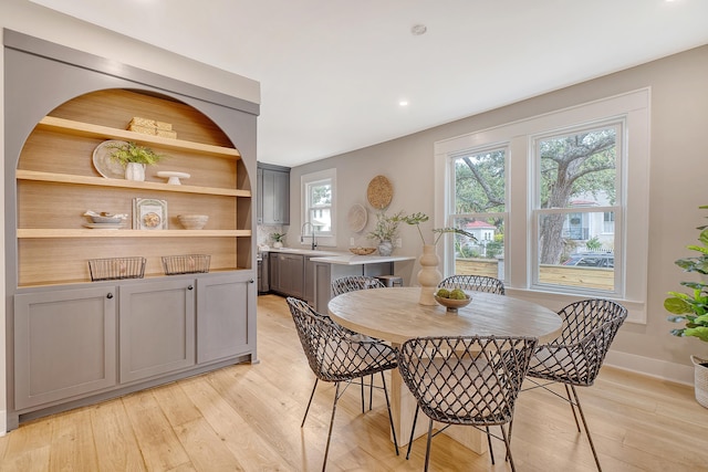 dining space with light hardwood / wood-style floors and sink