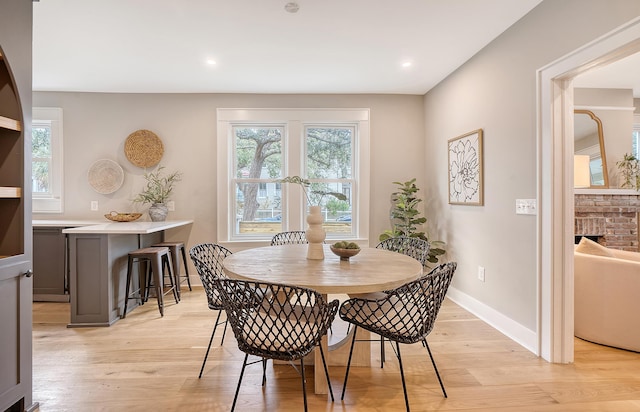 dining room featuring a fireplace and light hardwood / wood-style floors