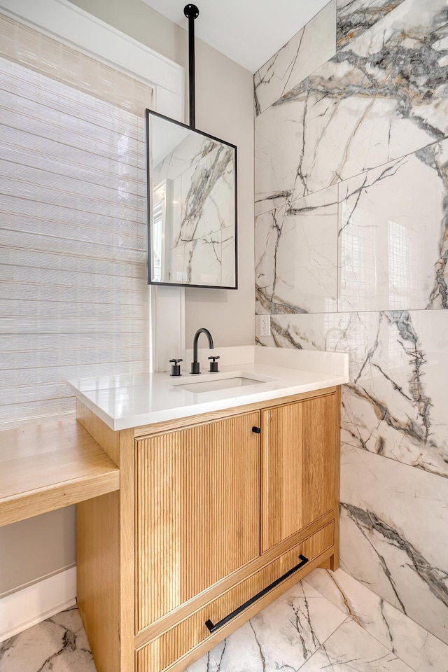 bathroom featuring vanity and tile walls