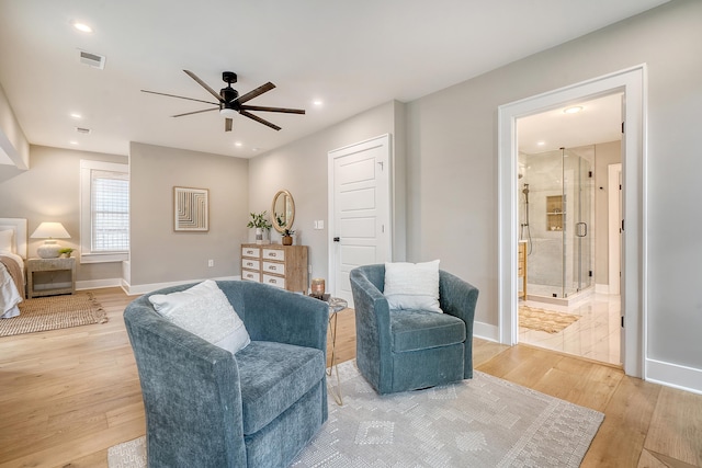 living area featuring light wood-type flooring and ceiling fan