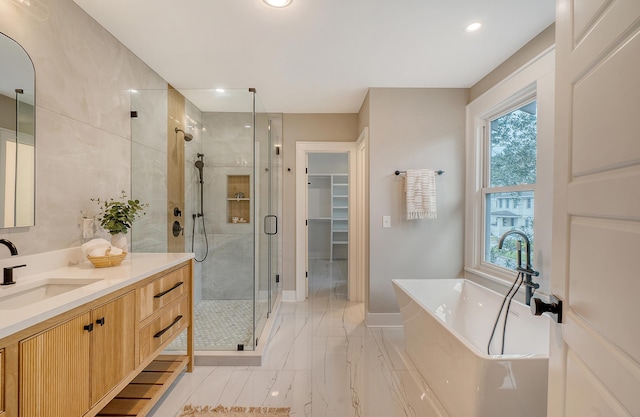 bathroom with vanity and shower with separate bathtub