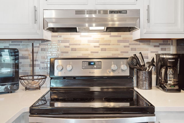 kitchen with decorative backsplash, stainless steel electric range oven, exhaust hood, and white cabinets