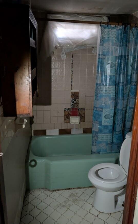 bathroom with shower / bath combo and toilet