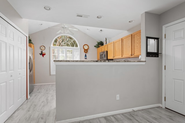 kitchen featuring ceiling fan, kitchen peninsula, vaulted ceiling, appliances with stainless steel finishes, and light hardwood / wood-style floors