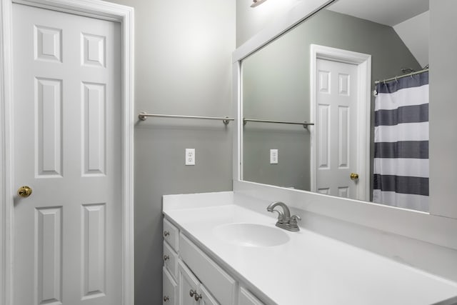 bathroom featuring lofted ceiling and vanity