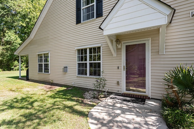 view of exterior entry with a yard