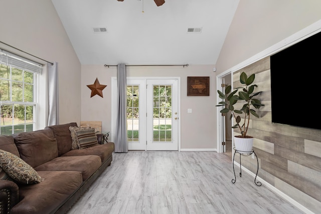 living room with ceiling fan, light wood-type flooring, and high vaulted ceiling