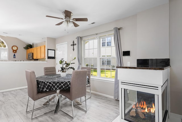 dining area featuring ceiling fan, light wood-type flooring, and plenty of natural light