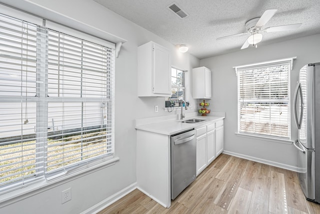 kitchen with sink, white cabinetry, stainless steel appliances, and a textured ceiling