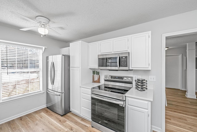 kitchen with a textured ceiling, white cabinetry, stainless steel appliances, light wood-type flooring, and ceiling fan