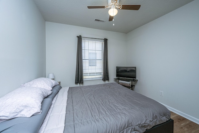 bedroom featuring a textured ceiling, ceiling fan, and hardwood / wood-style flooring