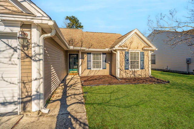 view of exterior entry with a lawn and a garage