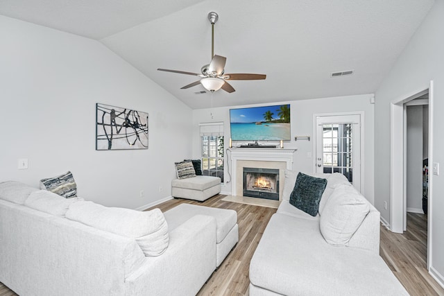 living room with ceiling fan, light hardwood / wood-style floors, and lofted ceiling