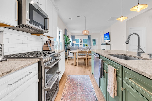 3789 Tupelo Branch Row, Mount Pleasant, SC 29429 - kitchen with stainless steel appliances, green cabinetry, light wood-style floors, white cabinetry, and backsplash