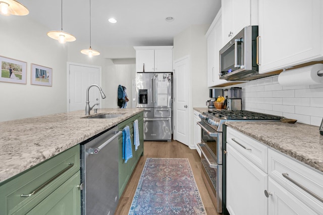 3789 Tupelo Branch Row, Mount Pleasant, SC 29429 - kitchen featuring stainless steel appliances, wood finished floors, white cabinets, backsplash, and hanging light fixtures