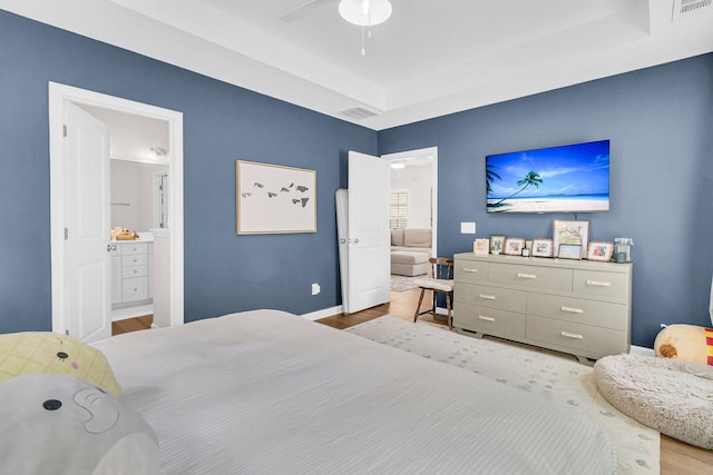 3789 Tupelo Branch Row, Mount Pleasant, SC 29429 - bedroom with wood finished floors, connected bathroom, a tray ceiling, and a ceiling fan