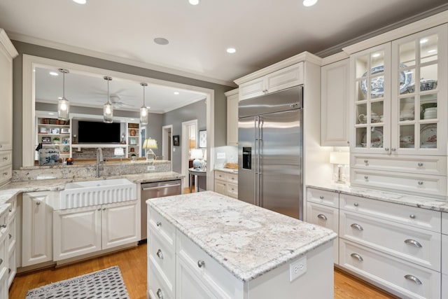 kitchen with sink, white cabinets, ceiling fan, ornamental molding, and appliances with stainless steel finishes