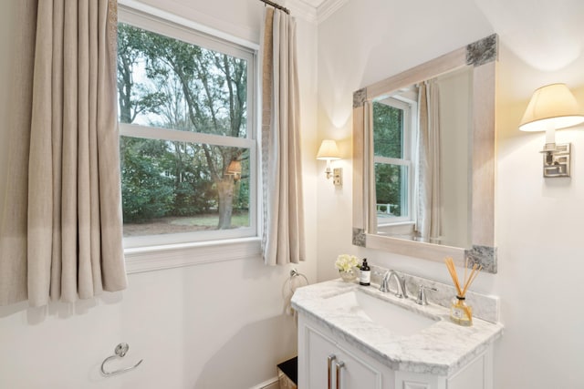 bathroom with vanity, a healthy amount of sunlight, and crown molding