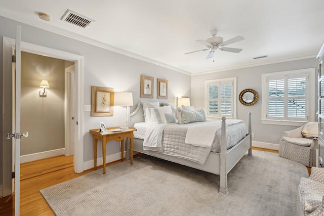 bedroom with crown molding, ceiling fan, and light hardwood / wood-style flooring