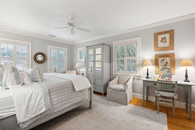 bedroom with ceiling fan, light wood-type flooring, and crown molding