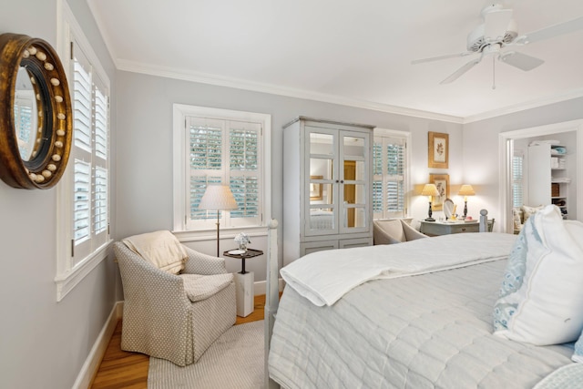 bedroom featuring ceiling fan, crown molding, and light wood-type flooring