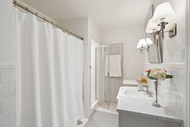 bathroom with tile walls, curtained shower, tile patterned floors, and vanity