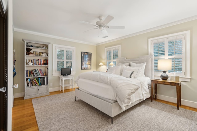 bedroom featuring ornamental molding, multiple windows, ceiling fan, and hardwood / wood-style floors