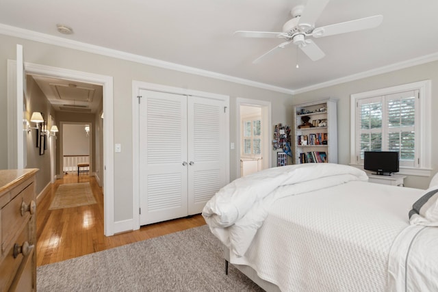 bedroom featuring ornamental molding, ceiling fan, light hardwood / wood-style floors, and a closet