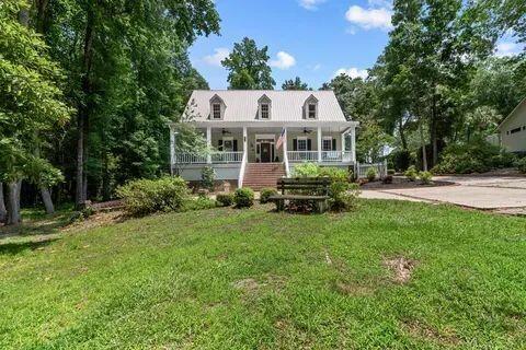 cape cod house featuring a front yard and covered porch