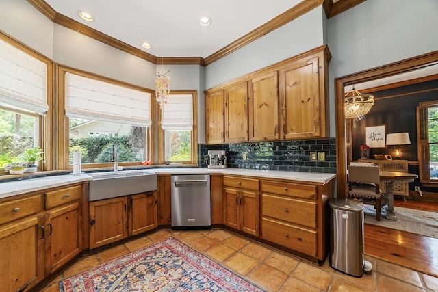 kitchen with tasteful backsplash, a notable chandelier, sink, and ornamental molding