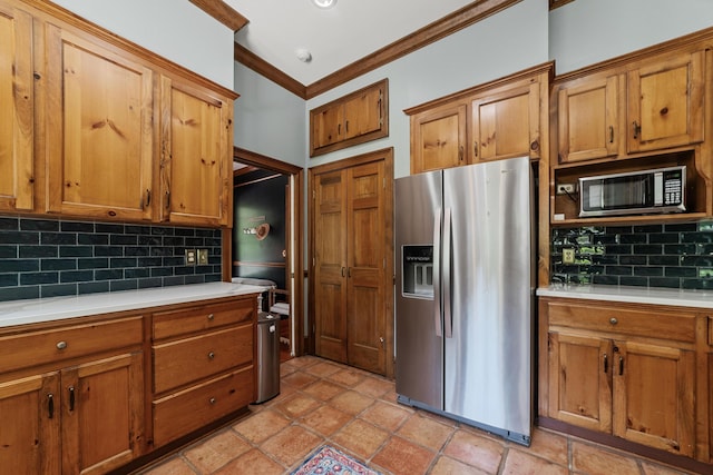 kitchen with crown molding, stainless steel fridge, and tasteful backsplash