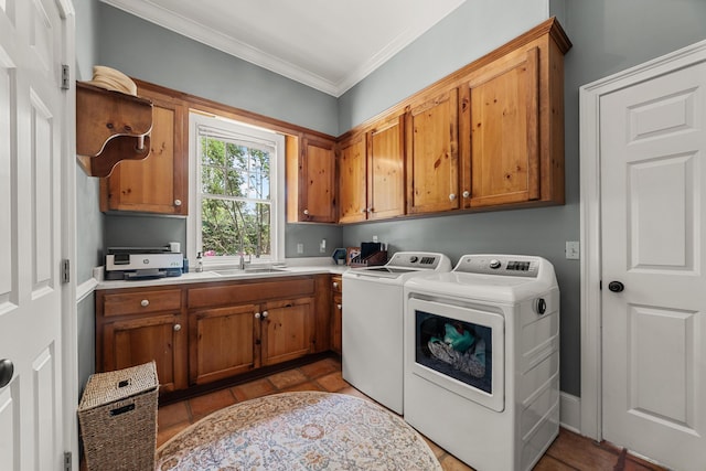 laundry room with cabinets, washing machine and clothes dryer, sink, light tile patterned floors, and crown molding