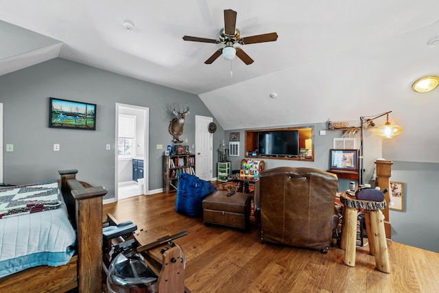 bedroom featuring vaulted ceiling, ceiling fan, hardwood / wood-style flooring, and ensuite bath