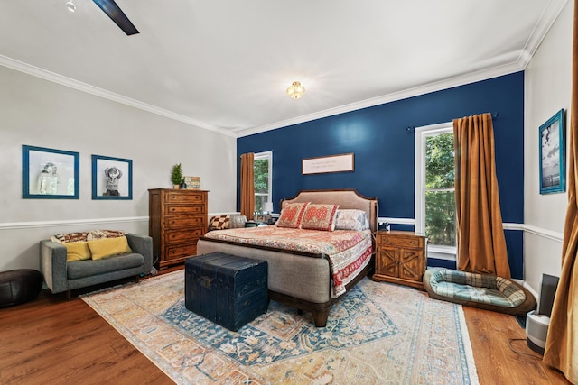 bedroom featuring ceiling fan, crown molding, and hardwood / wood-style flooring