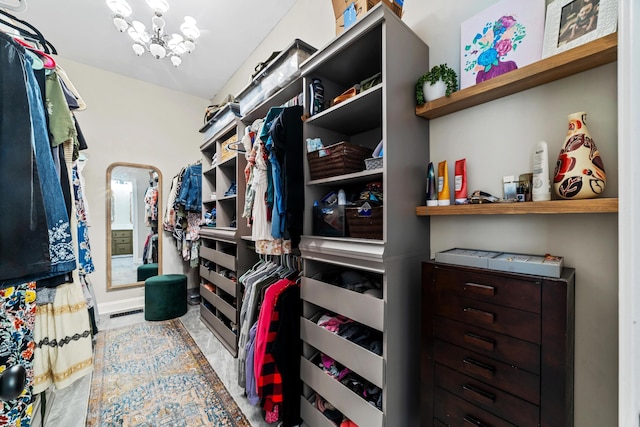 spacious closet featuring a chandelier