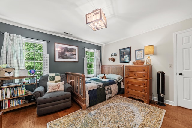 bedroom featuring ornamental molding and wood-type flooring